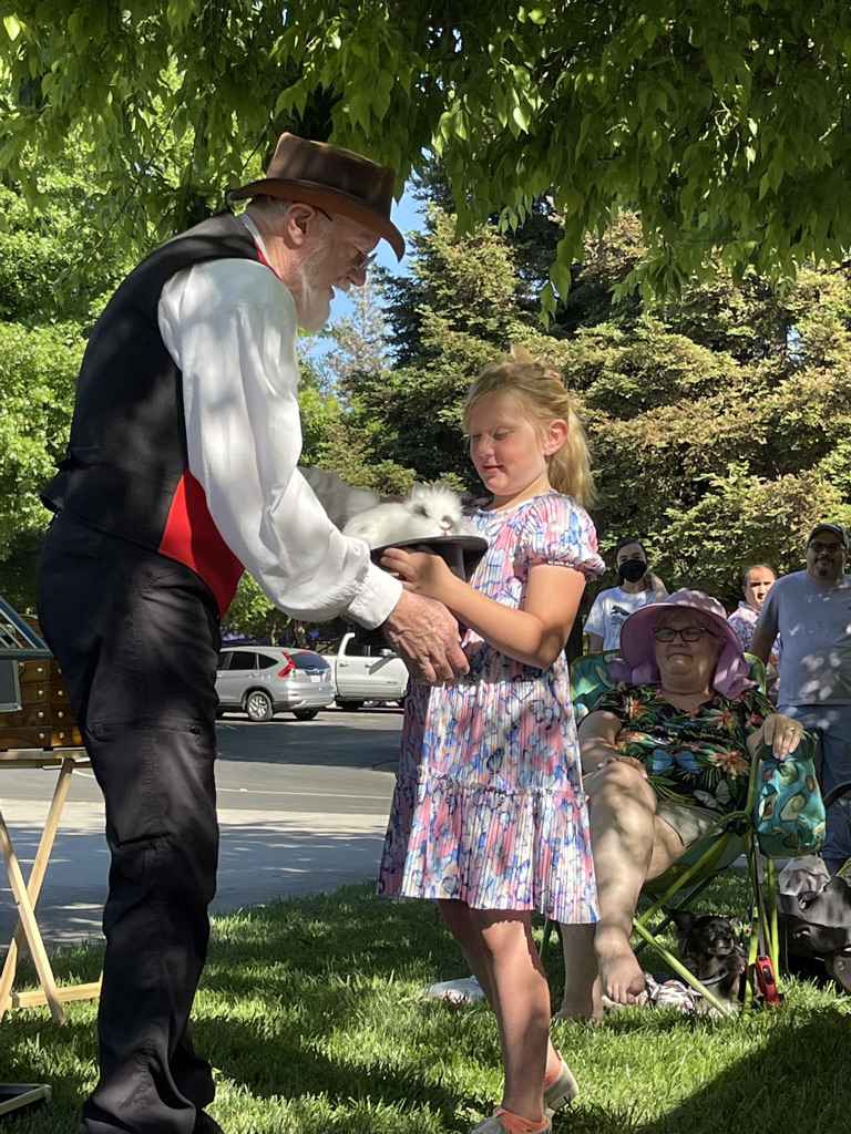 Ric the Magician and a family event with rabbit in a hat and girl volunteer